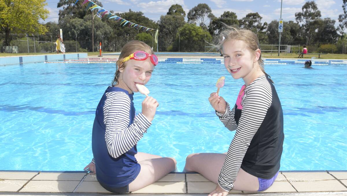 More heat on the way: Lila and Ava Tadich cool off at Brennan Park Public Pool. Picture: NONI HYETT