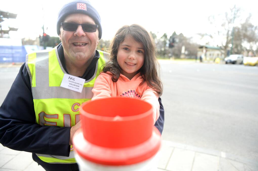 SUPPORT: Golden Square Country Fire Authority volunteer Paul Davis with Isabella collecting change at the Alexandra Fountain in Bendigo on Saturday. About 30 volunteers took part. Picture: DARREN HOWE