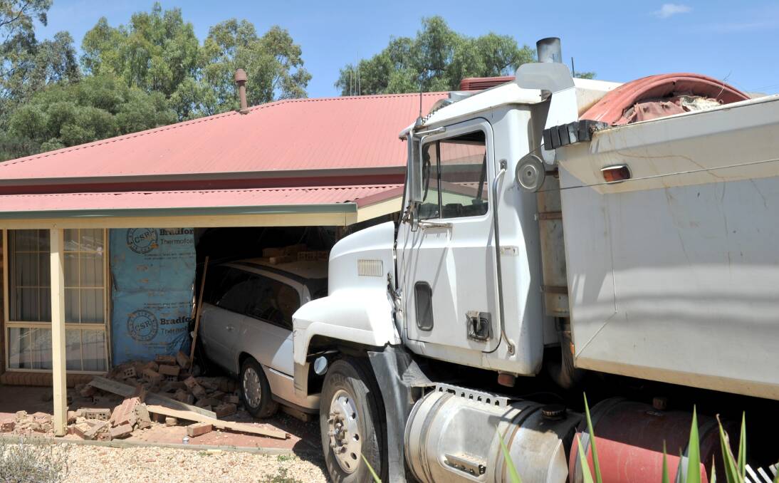 A runaway truck crashed into a car, which crashed through the walls of a house. Picture: NONI HYETT