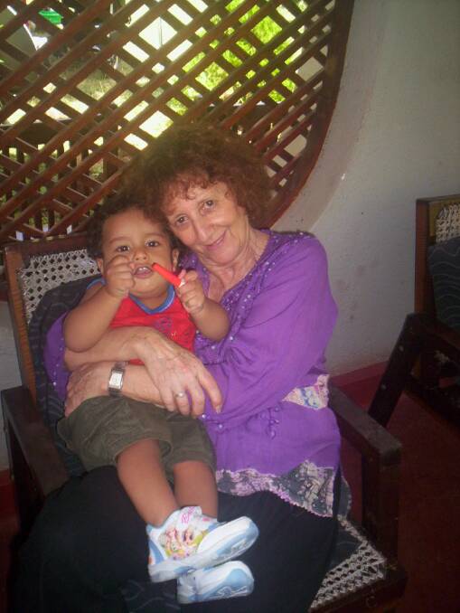 GRANDMOTHERLY LOVE: Gloria Meltzer cuddles up to her Sri Lankan grandson during one of her overseas trips. Picture: SUPPLIED
