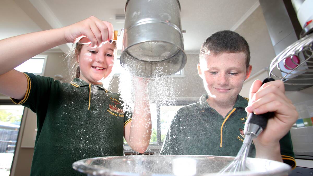 PANCAKE DAY: Abbie Fisher and Kalum Adams from St Peter's Primary School getting the kitchen ready to make pancakes for Shrove Tuesday. Picture: GLENN DANIELS
