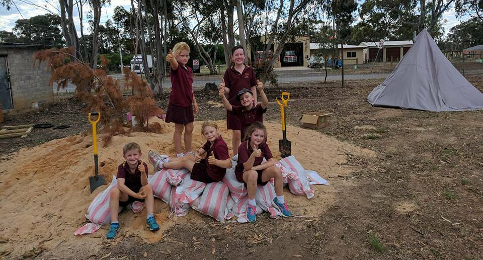 Axedale's Natural Learners kids fill sandbags for local residents. Picture: Facebook