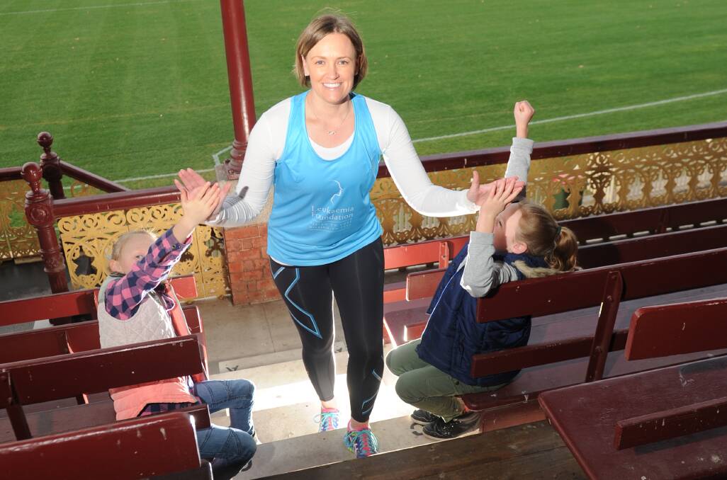 PRACTICE: Jayne Demeo climbs the steps of the grandstand at the Queen Elizabeth Oval supported by her daughters Ruby and Jordyn. Picture: NONI HYETT