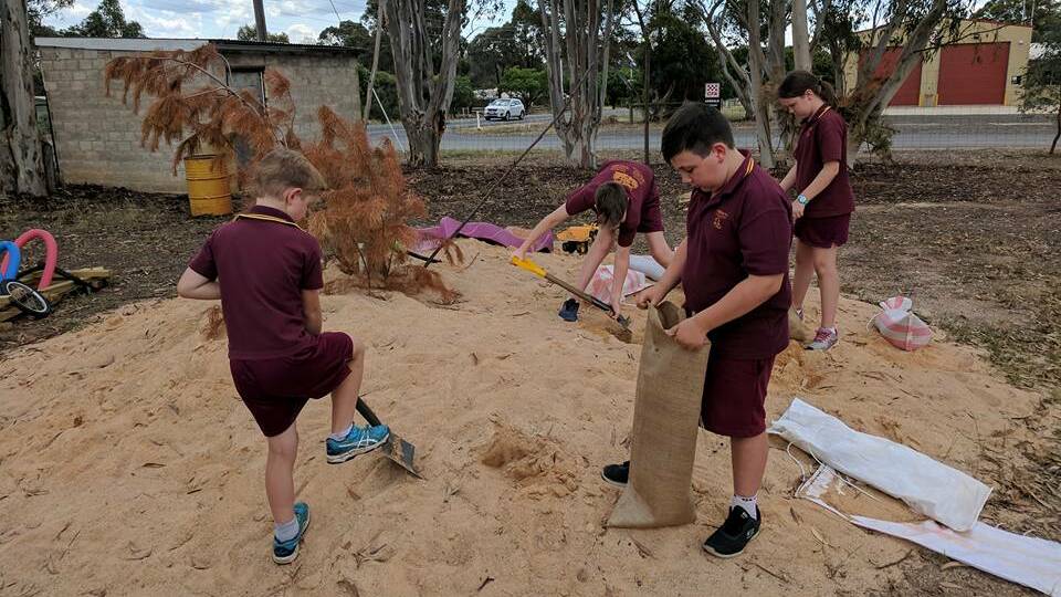 Axedale's Natural Learners kids fill sandbags for local residents. Picture: Facebook
