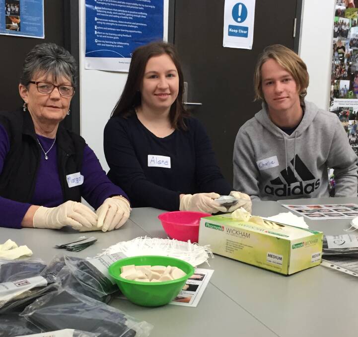 VOLUNTEERS: Margaret Honeybone, Alana Parkes and Charlie Parkes spent the day packing birthing kits to send to third-world countries. Pictures: CHRIS PEDLER