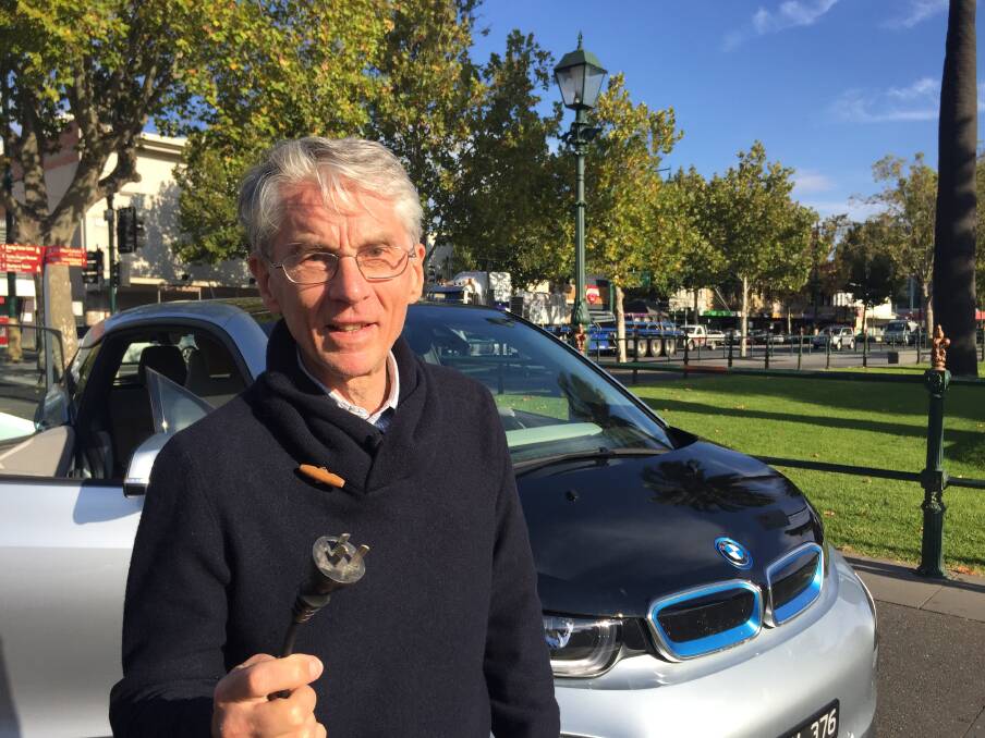 THE FUTURE?: Ian Jones with the cord that connects to power stations that charges his electronic vehicle - a BMW i3. 