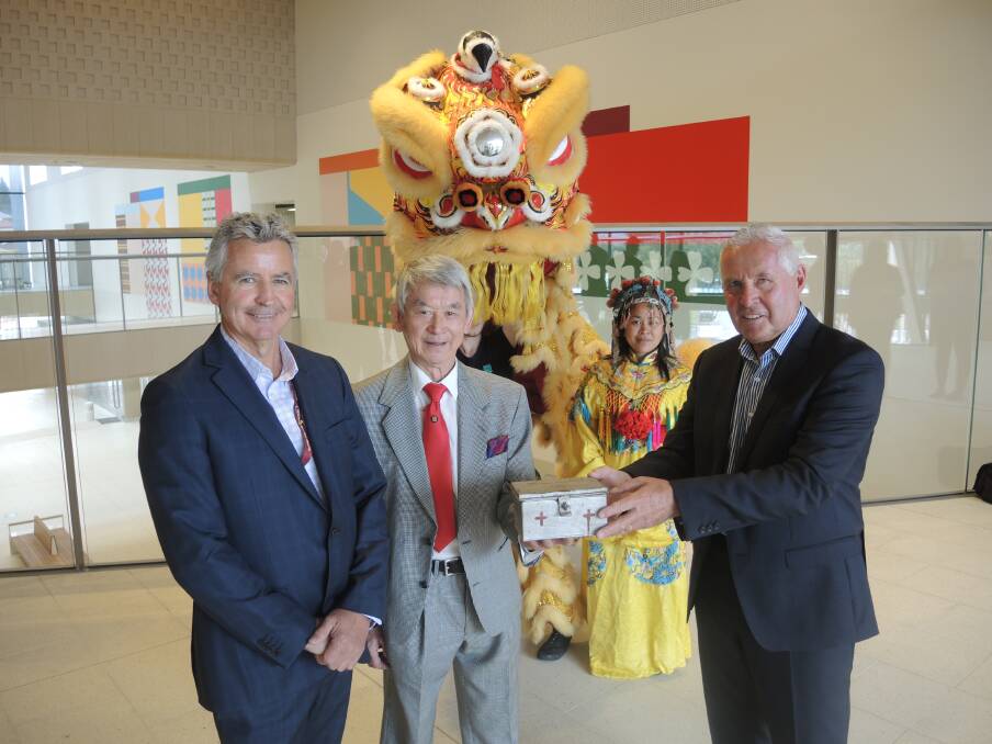 GIVING: Bendigo Health CEO John Mulder, Golden Dragon Museum's Russell Jack and committee chairman Keith Sutherland with a historical donation box from the Chinese community.