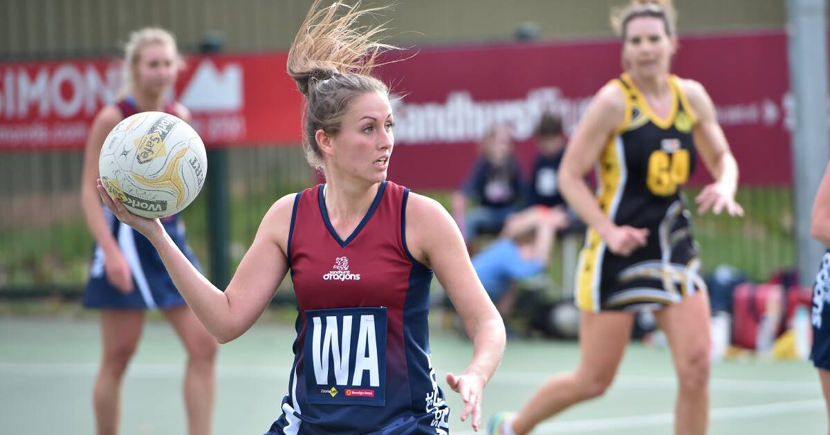 WINNING MOMENTUM: Sandhurst's Brooke Bolton looks to pass the ball off to a teammate during the Dragons' win over Kyneton at the QEO. Picture: NONI HYETT