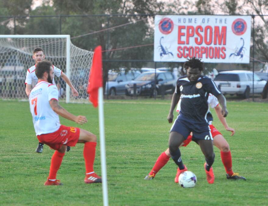 TAKING THE GAME ON: Abraham Lokiru takes on a pair of Murray United defenders during Saturday's NPL2 game at Epsom Huntly Recreation Reserve.
