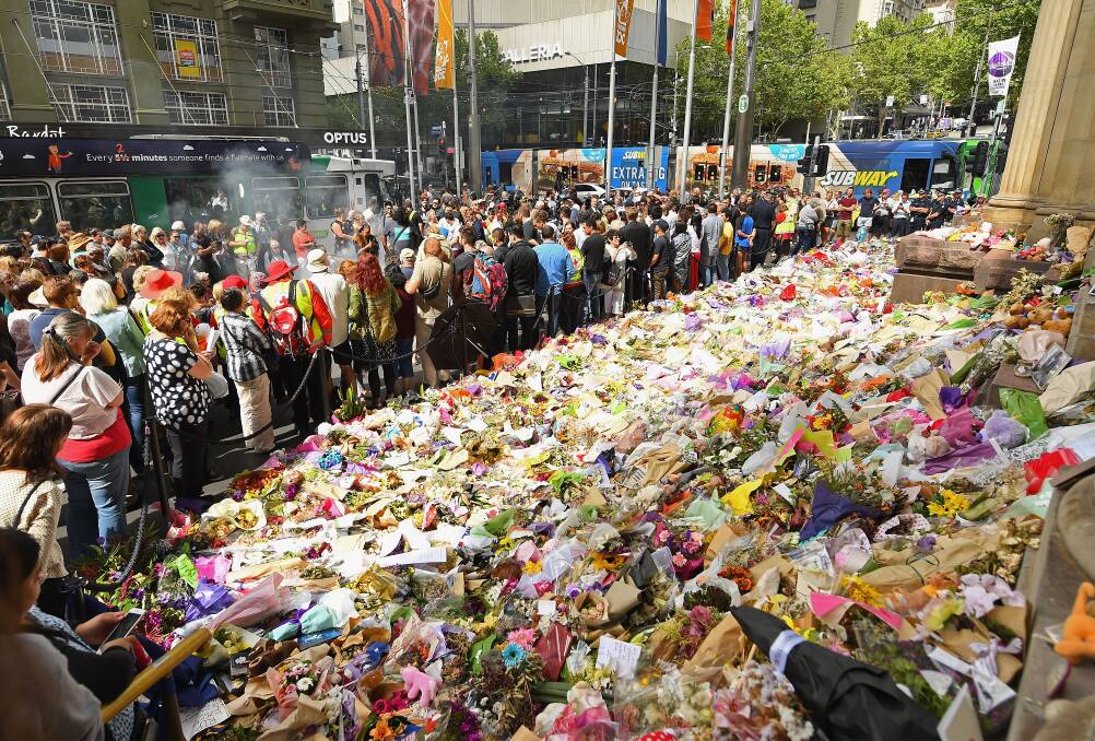 GRIEF STRICKEN: Mourners gather on Bourke Street in the wake of a tragedy never previously seen in Melbourne. 