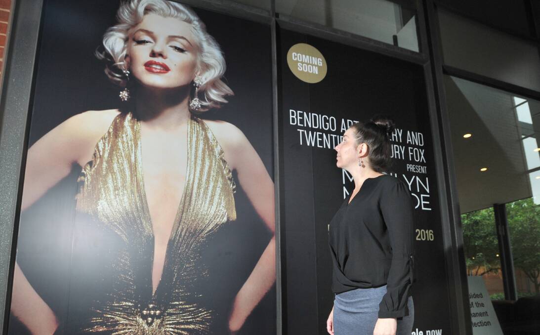 STARSTRUCK: Sandra Bruce looks up to the Marilyn poster at Bendigo Art Gallery. Both will be dwarfed by the piazza statue. Picture: NONI HYETT