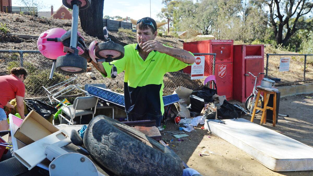 FULLY LOADED: Michael Johnston loads up a trailer rubbish left at Salvos bins that should've been taken to the tip. Picture: DARREN HOWE