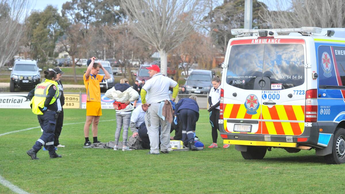 Maryborough's Ash Noonan is treated by ambulance officers at Princes Park on Saturday. Picture: ADAM BOURKE