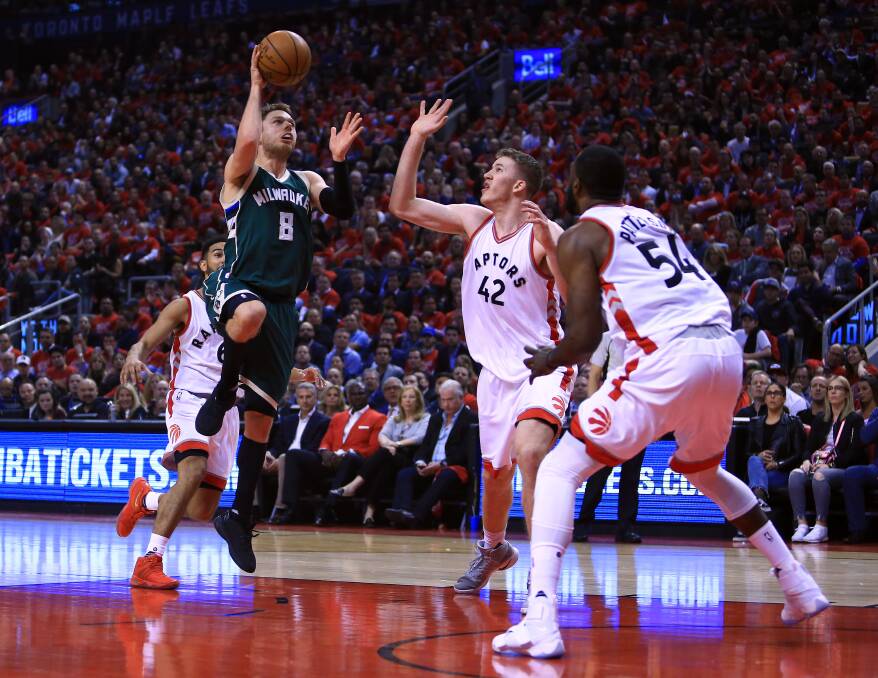 RUNNING JUMPER: Matthew Dellavedova tries to score above two Toronto opponents in game two of the play-offs. Picture: GETTY IMAGES