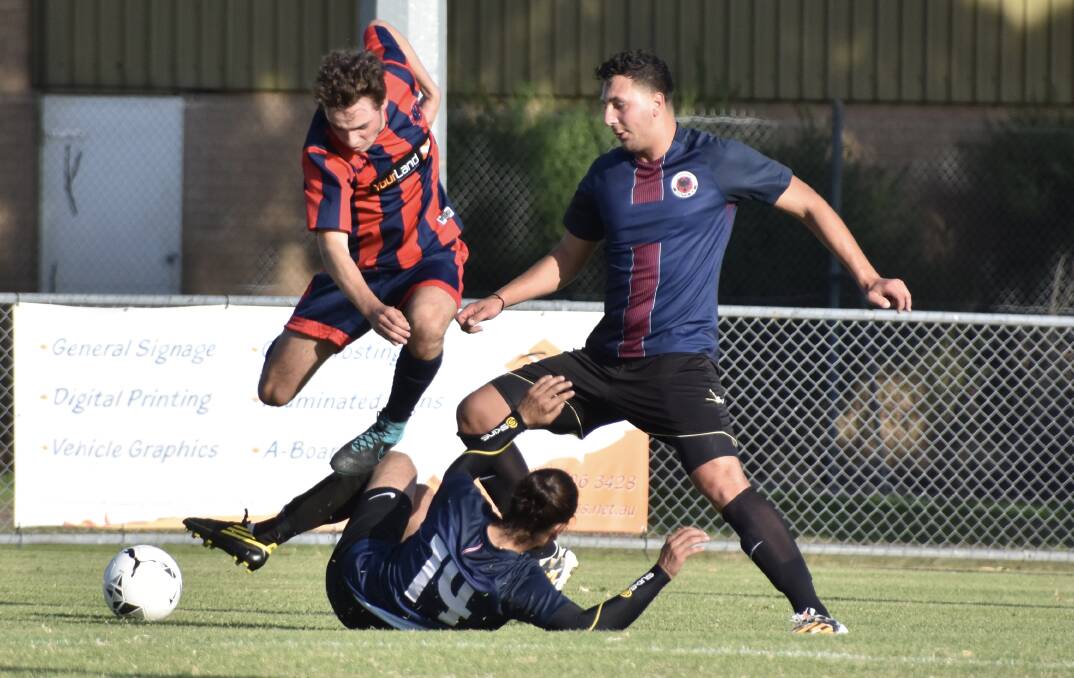 UP AND OVER: Epsom midfielder Josh Claney leaps over two Dandenong South defenders. Pictures: LIZ GRACO