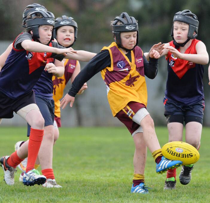 QUICK KICK: Action from the St Therese's and Quarry Hill under-12D clash in the Bendigo Junior Football League at Ewing Park on Sunday. Picture: DARREN HOWE
