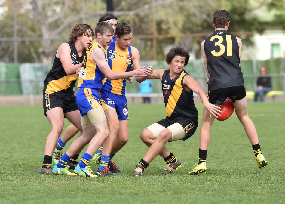 TIGHT TUSSLE: Golden Square and Kyneton players battle for the ball in Sunday's junior footy clash at Golden Square. Picture: NONI HYETT