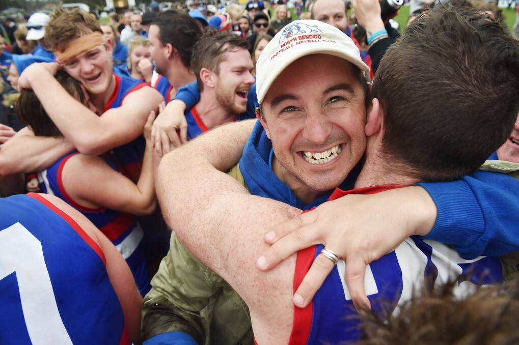 Rob Bennett embraces his players after North Bendigo's premiership win in 2016. Picture: DARREN HOWE