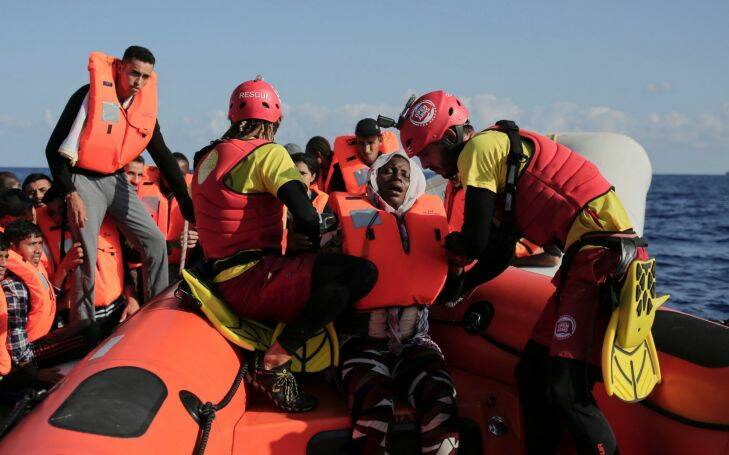 Members of the Spanish NGO ProActiva Open Arms rescue Peace, a refugee woman from Ghana, from a rubber dinghy on the Mediterranean Sea, Wednesday, Sept. 6, 2017. ProActiva Open Arms rescued more than 200 migrants Wednesday morning from foundering rubber dinghies about 25 miles north of the Libyan coastal town of al-Khums. Peace gave birth to a girl onboard the Spanish NGO vessel immediately after being rescued. (AP Photo/Bram Janssen)