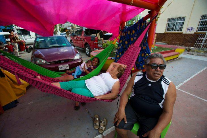 People whose homes have been left uninhabitable by Thursday's magnitude 8.1 earthquake camp out in a plaza in Juchitan, Oaxaca state, Mexico, Sunday, Sept. 10, 2017. Life for many has moved outdoors in the quake-shocked city of Juchitan, where a third of the homes are reported uninhabitable and repeated aftershocks have scared people away from many structures still standing. (AP Photo/Rebecca Blackwell)