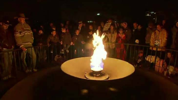 People look on to the eternal flame at the Melbourne dawn service. Photo: Nine news Melbourne Twitter
