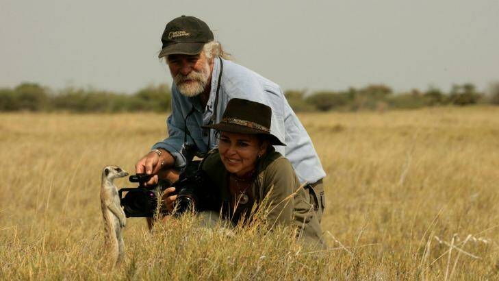 Dereck and Beverly Joubert observing a meerkat in the Okavango Delta, Botswana.