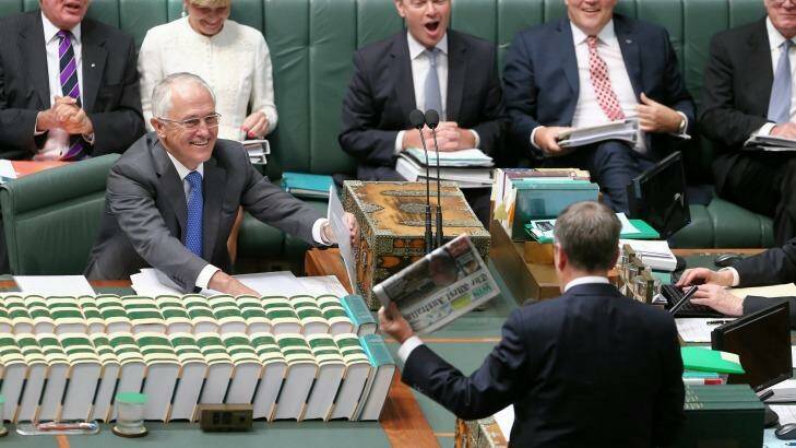 Opposition Leader Bill Shorten wields a newspaper with a report on Medicare changes during question time. Photo: Alex Ellinghausen