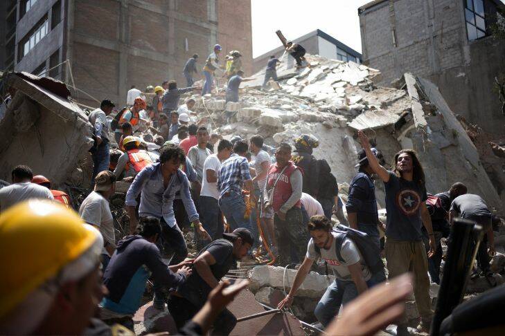 People remove debris from a collapsed building following an earthquake in the neighborhood of Condesa, Mexico City, Mexico, on Tuesday, Sept. 19, 2017. A powerful 7.2 magnitude earthquake struck near Mexico City, toppling buildings and extinguishing lights as thousands of people fled. It was the nation's second major earthquake this month, and struck 32 years to the day after a temblor with an 8.0 magnitude killed 5,000 people.?? Photographer: Alejandro Cegarra/Bloomberg