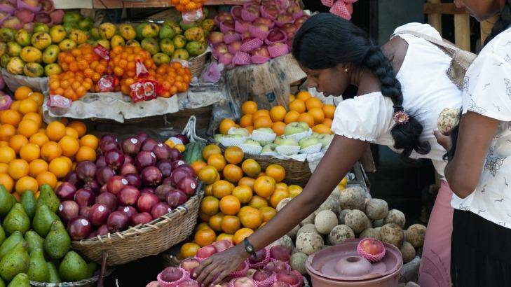 A woman selects fruit from a stall in Galle.