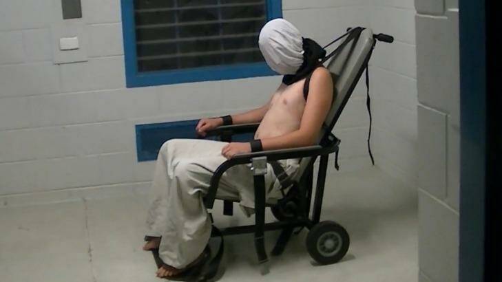 Dylan Voller is hooded an strapped into a restraining chair in the <i>Four Corners</i> footage. Photo: ABC Four Corners