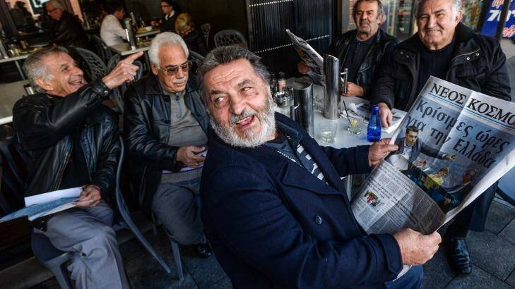 Read all about it: Peter Kanellakis discusses the headlines with friends in a cafe in Oakleigh. Photo: Justin McManus