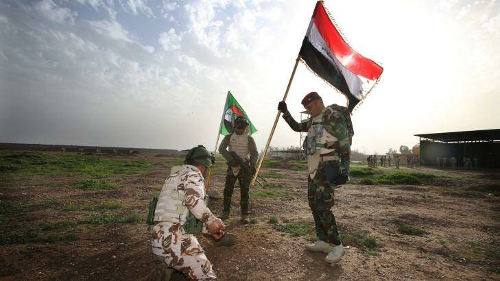 Taji Iraq. Iraqi soldiers plant the nation's flag at the range.  Photo: Gary Ramage
