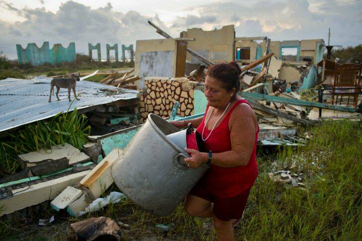 Lourdes Rivera loads a few buckets to collect water in front of her house that was destroyed by Hurricane Irma, in Isabela de Sagua, Cuba, Monday, Sept. 11, 2017. Cuban state media reported several deaths despite the country's usually rigorous disaster preparations. More than 1 million were evacuated from flood-prone areas. (AP Photo/Ramon Espinosa)