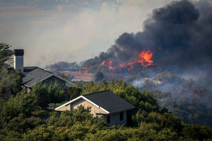The Uintah Fire burns through residential areas near the mouth of Weber Canyon on Tuesday, Sept. 5, 2017. Strong winds drove the grass fire into surrounding neighborhoods where it destroyed homes and forced residents to evacuate. (Benjamin Zack/Standard-Examiner via AP)