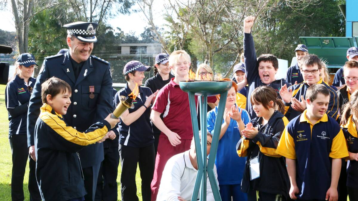 Inspector Brad Dixon and athlete Jed Manton light the Olympic flame to open the Regional Special Olympics Victoria regional games competition. 