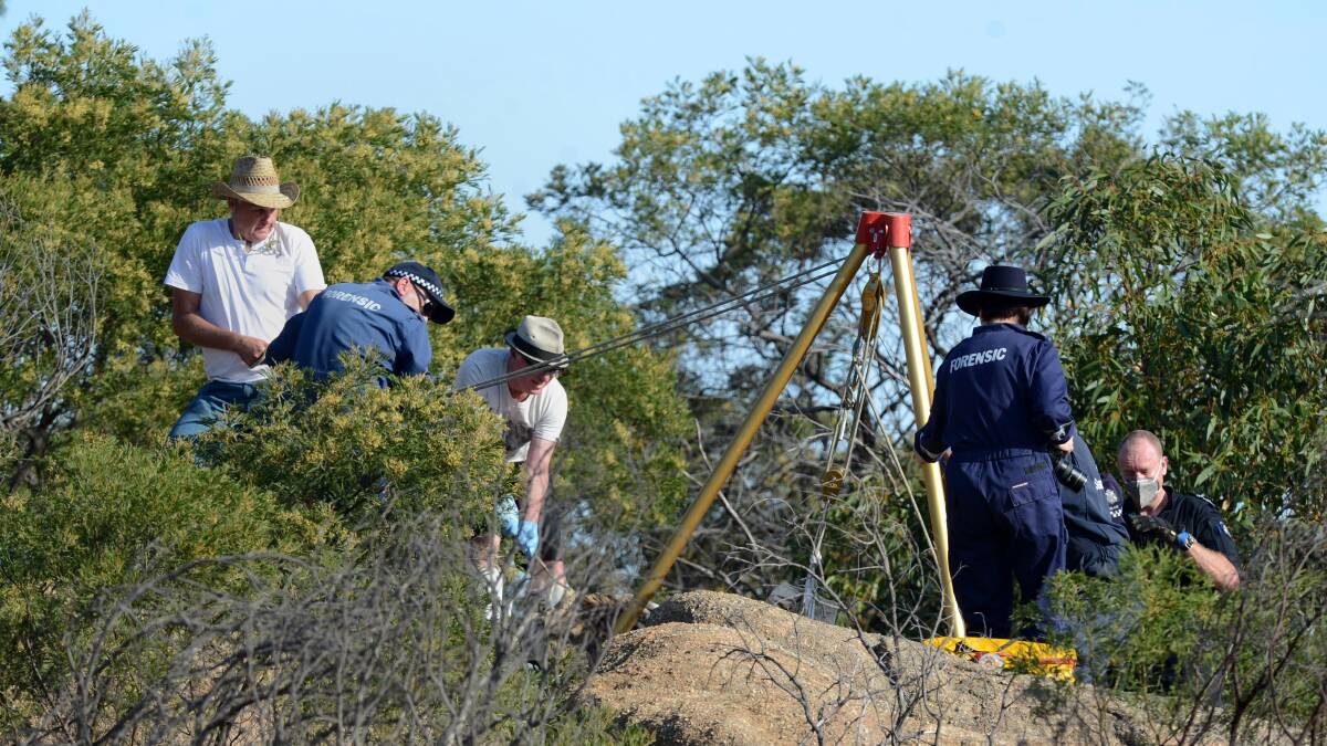 Police pull Wayne Amey's body from between two rocks on Mt Korong.

Picture: JIM ALDERSEY
181213