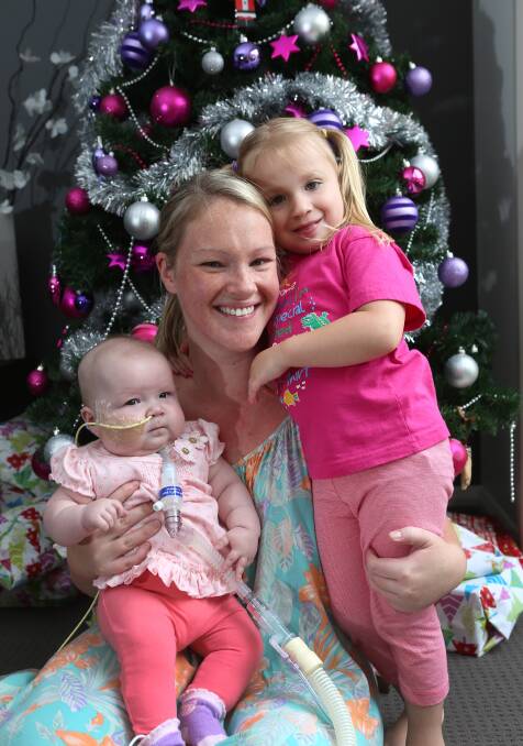 Evie with mum Emily Stove and sister Isabella. Picture: PETER WEAVING