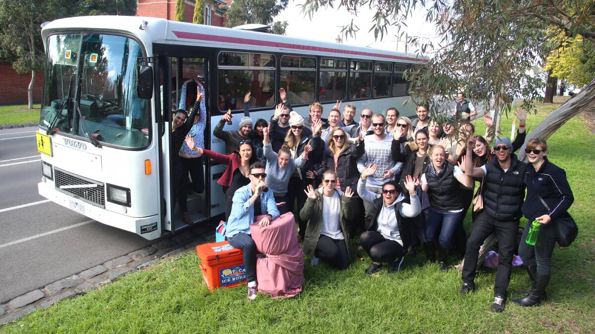 CHEERS: The group with their bus. Picture: PETER WEAVING
