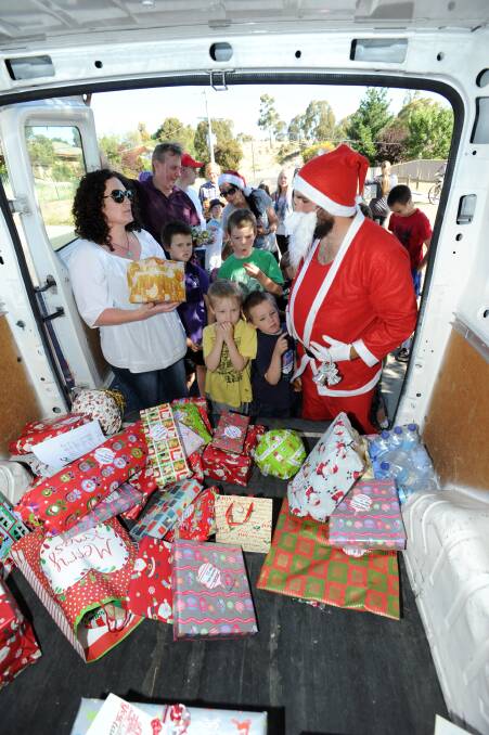 DELIVERY: Santa hands out presents to children in Long Gully. Picture: JODIE DONNELLAN 
