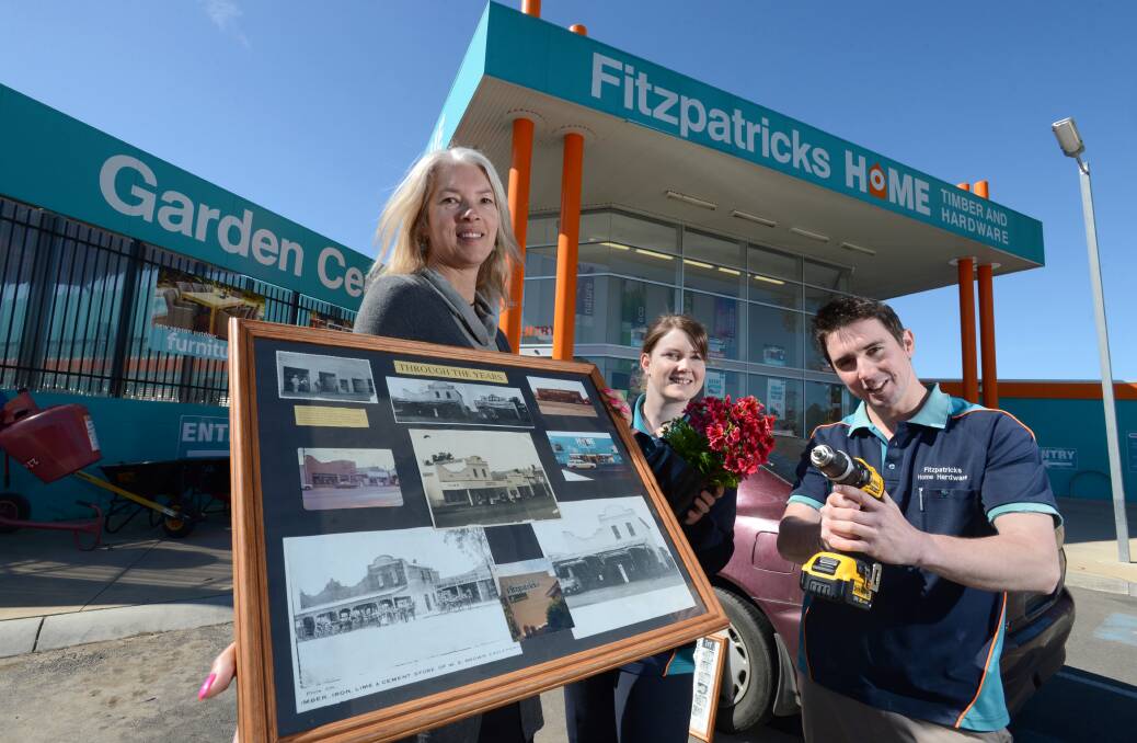 Kim Fitzpatrick holds images of the old Fitzpatrick Hardware stores over their 90 year existance with Heidi Packham and Jayden Rice. The store will be celebrating 90 years next month. Picture: JIM ALDERSEY