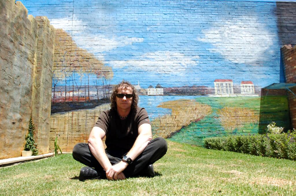 Aaron Stevenson with his giant mural. Picture ; PETER HYETT.