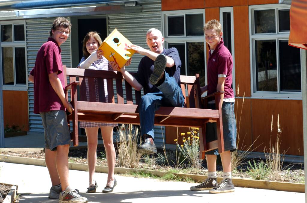 Paul Kirkpatrick, Chairman of the Camp Getaway Campsite Committee, gets a lift on one of the chair made by Weeroona College students Will Blair, Natasha Bryant and Matt Moore. Picture ; PETER HYETT.