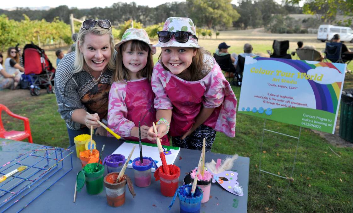 Megan Howes with Ruby, 7 and Chloe Hill, 11 paint a canvas at the Colour Your World Art Studio table. 
