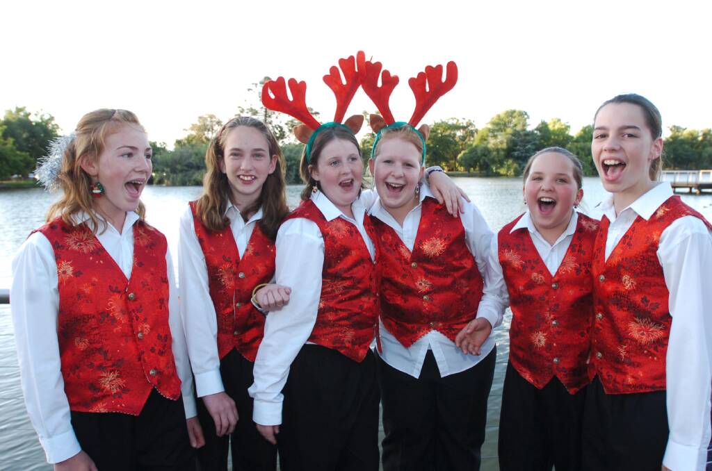 Jennifer, Bianca, Olivia, Melody, Kayla, and Rechelle from the Bendigo Youth Choir warm up before the carols at the Rotary carols by candlelight at Lake Weeroona
pic by Bill Conroy.