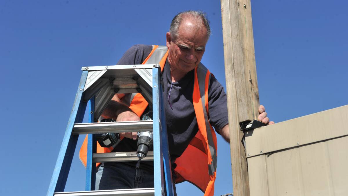 REPAIRS: A man repairs the power line, which was attached to a portable. Picture: BLAIR THOMSON