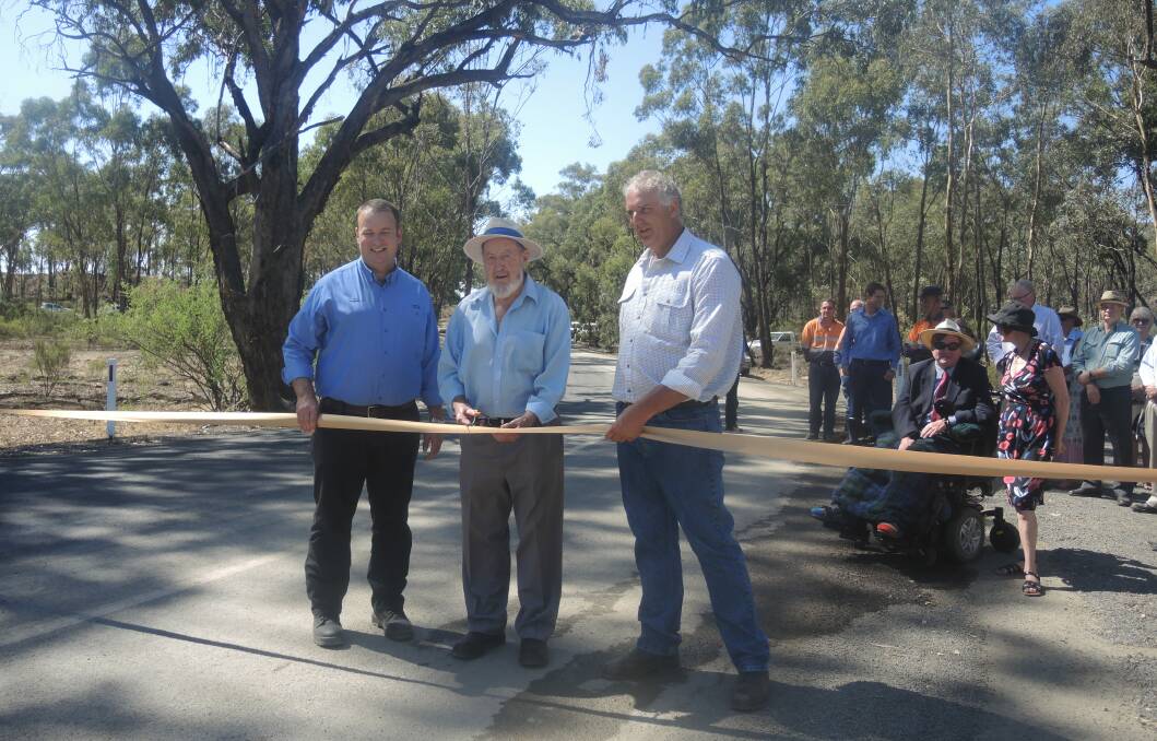 OPEN: Fosterville Gold Mine general manager Ian Holland officially opens the stretch of road with nearby residents Barry Windsor and Tim Harrington.