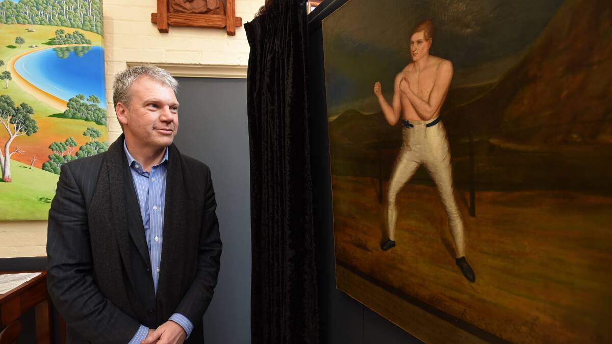 Peter Valentine with the painting of William Abednego Thompson, the man behind the name "Bendigo".