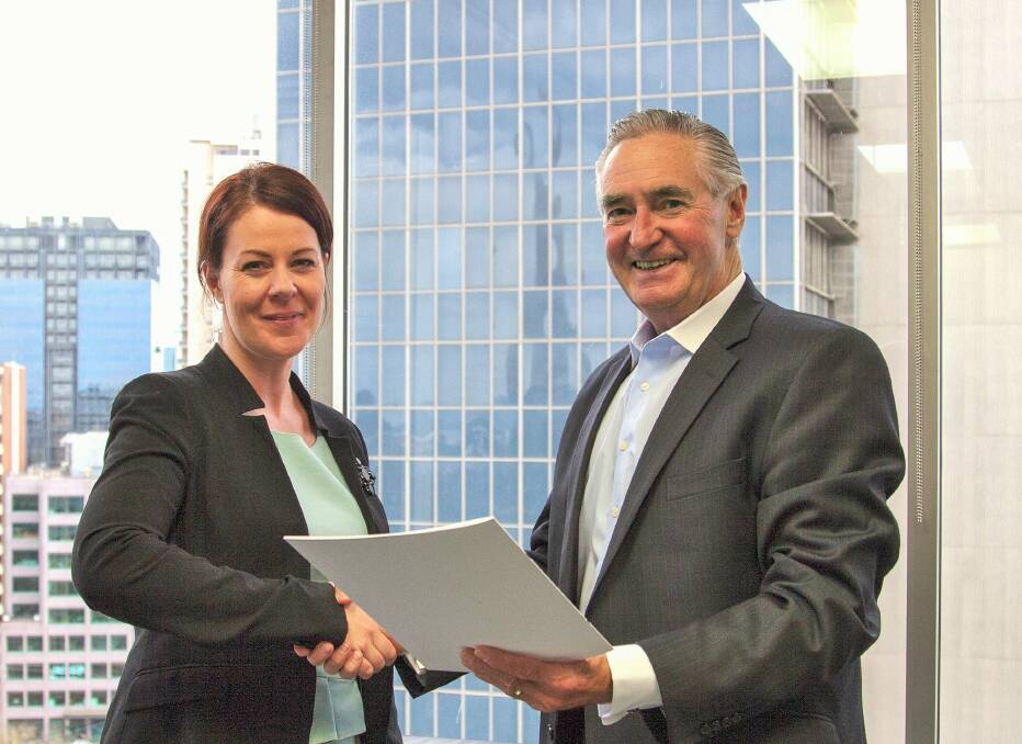 Bendigo Business Council chief executive officer Leah Sertori and VECCI chief executive officer Mark Stone shake hands on the agreement.