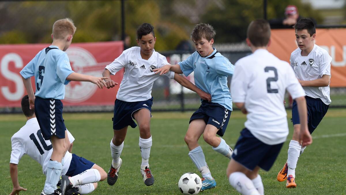 FIERCE RIVALS: Victoria takes on New South Wales on day four of the School Sport Australia 12-under football championships in Bendigo. Picture: JODIE DONNELLAN