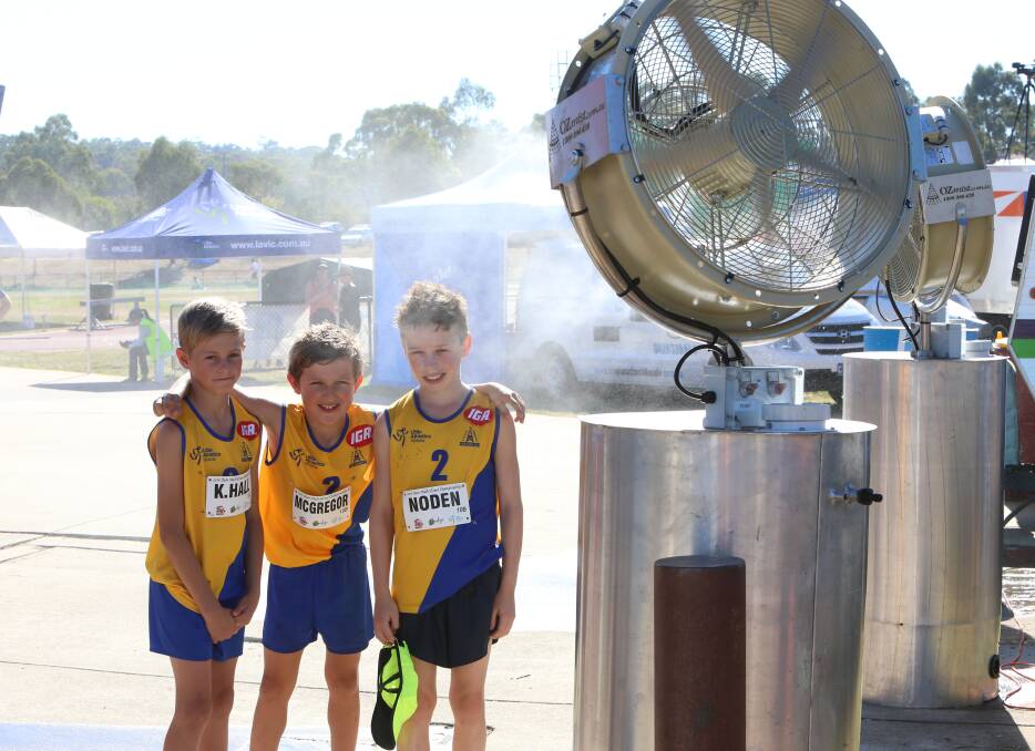 IT'S COOL: Kobi Hall, Blake McGregor and Matthew Noden take advantage of the water misting fan at the Little Athletics Victoria multi-event championships run in Bendigo. Picture: PETER WEAVING 